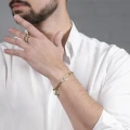 Unisex-Armband in Goldfarbe mit einem Büroklammer-Anhänger aus der Machiny-Kollektion von ORSKA Jewelry