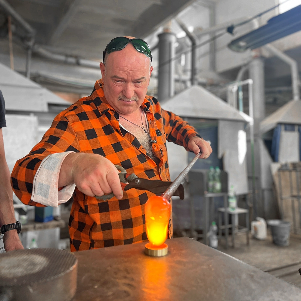 Glasarbeiter formt Glas in der Glashütte Julia